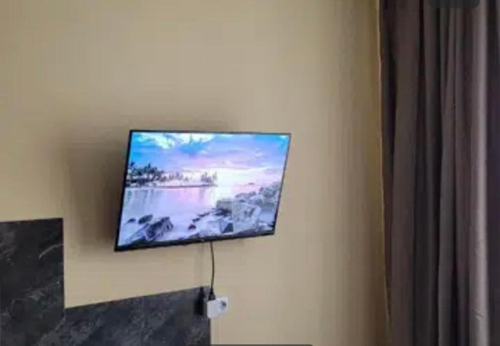 uma televisão de ecrã plano pendurada numa parede em VIP apart 794 em Tbilisi