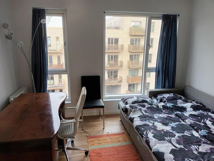1 dormitorio con 1 cama, escritorio y ventanas en Fully equipped apartment, 15 min to Center, en Copenhague