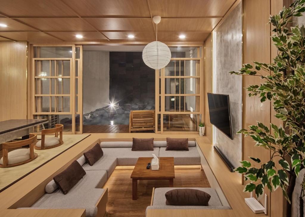 a living room with a couch and a table at Yama Onsen Villa in Bandung