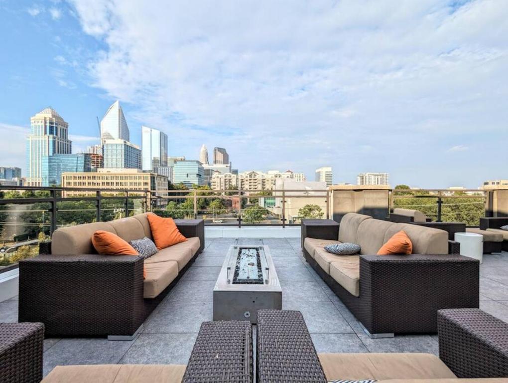 a rooftop patio with couches and a view of the city at League Flats South End at South Blvd in Charlotte