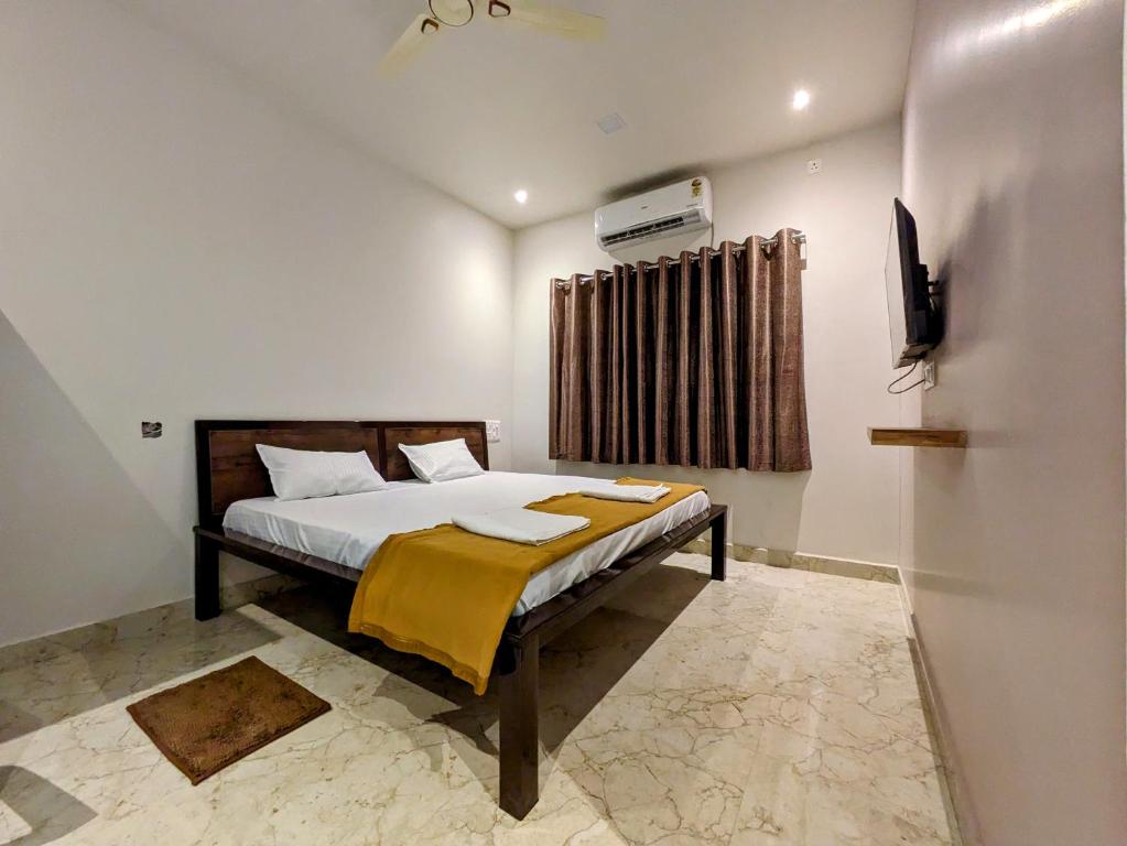 1 dormitorio con 1 cama y TV en Hotel Madhusudan Executive, en Kolhapur