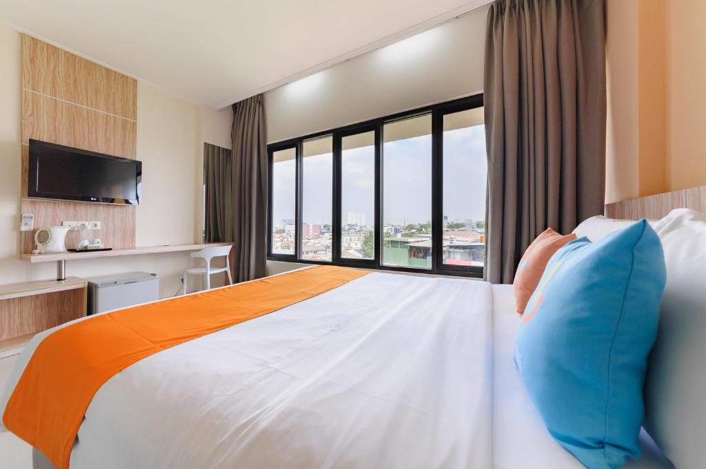 Postel nebo postele na pokoji v ubytování Sans Hotel The Green Bekasi by RedDoorz