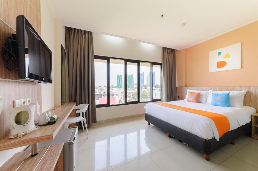 Habitación de hotel con cama grande y TV en Sans Hotel Green Bekasi by RedDoorz, en Bekasi