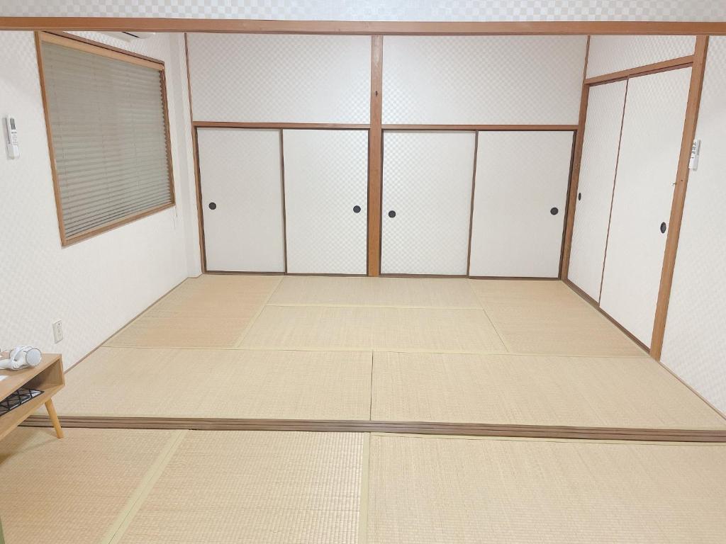 um quarto vazio com armários brancos e pisos de madeira em Cate no mori - Vacation STAY 30749v em Shime