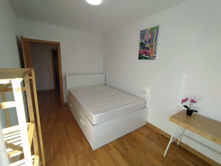 a white room with a bed in the corner at Apartamento en Astillero con plaza de aparcamiento in El Astillero