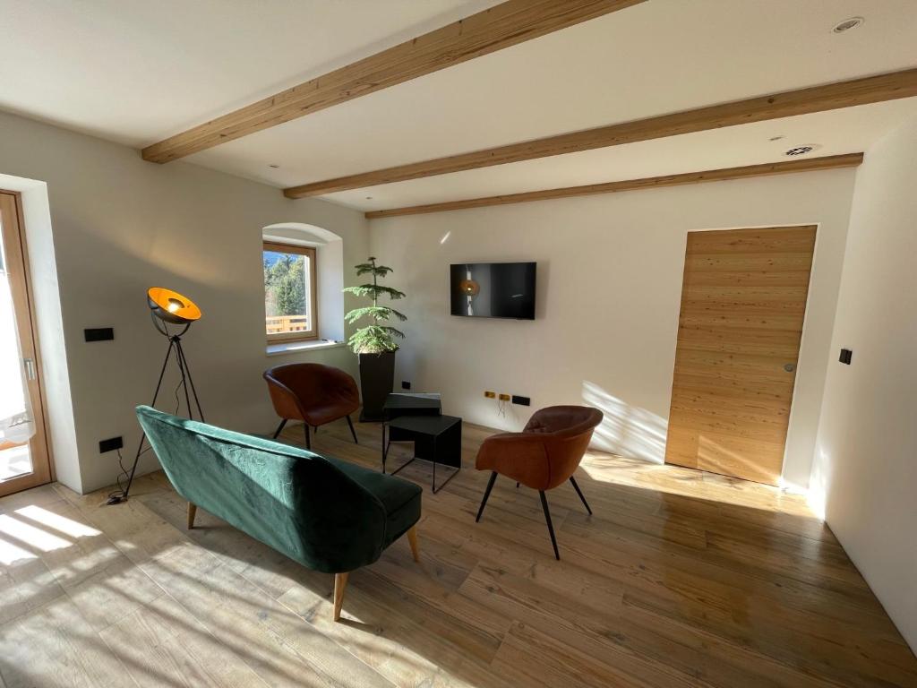 sala de estar con sofá verde y sillas en Appart-Chalet con vista sulla Litegosa, en Panchia