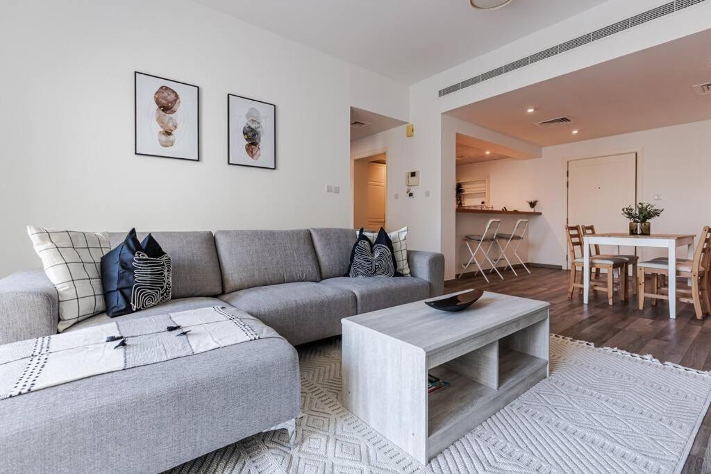a living room with a couch and a table at Serene & Spacious 1BR The Greens in Dubai