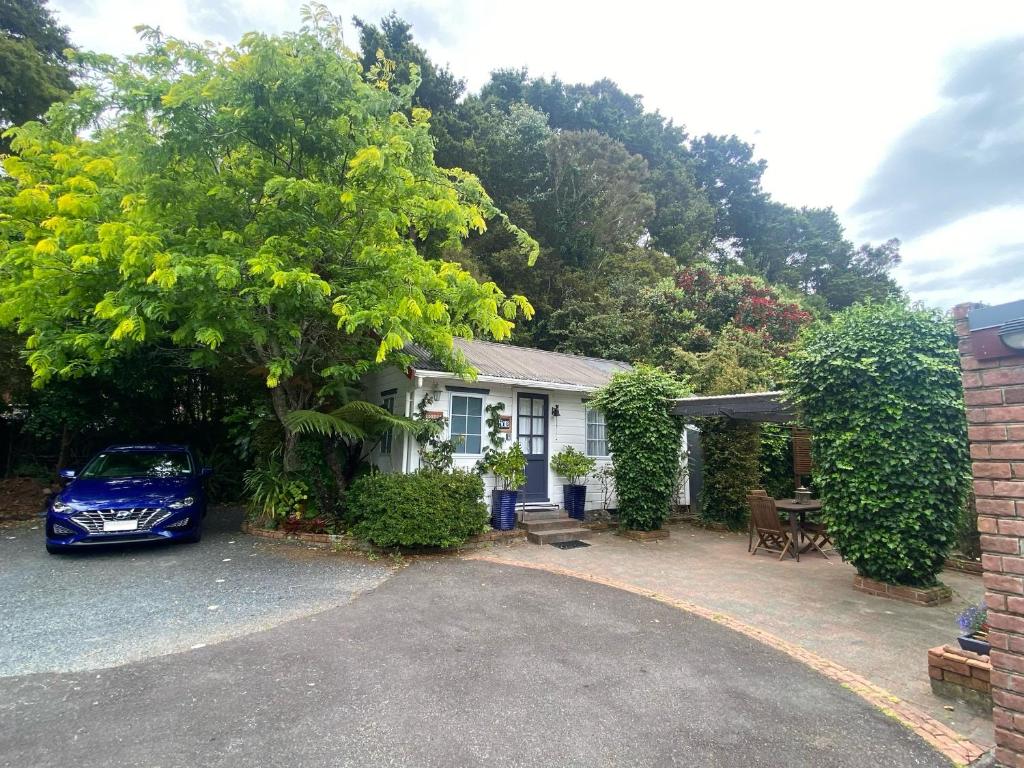 un coche azul estacionado frente a una casa en Paihia Place Cottage - central Paihia, en Paihia