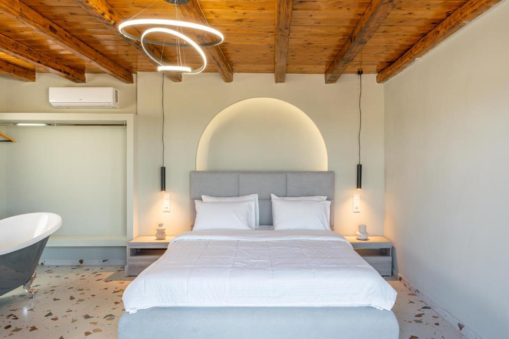 1 dormitorio con 1 cama blanca grande y baño en Athali villa en Krousón
