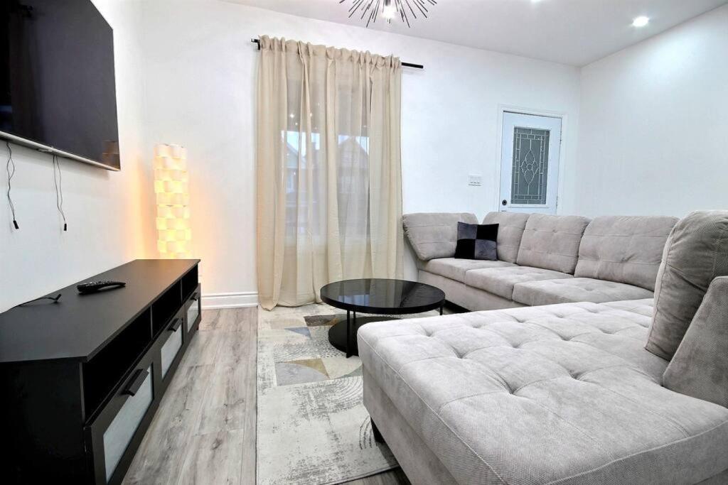 sala de estar con sofá y mesa en Luxury home by Tim Hortons Field, en Hamilton