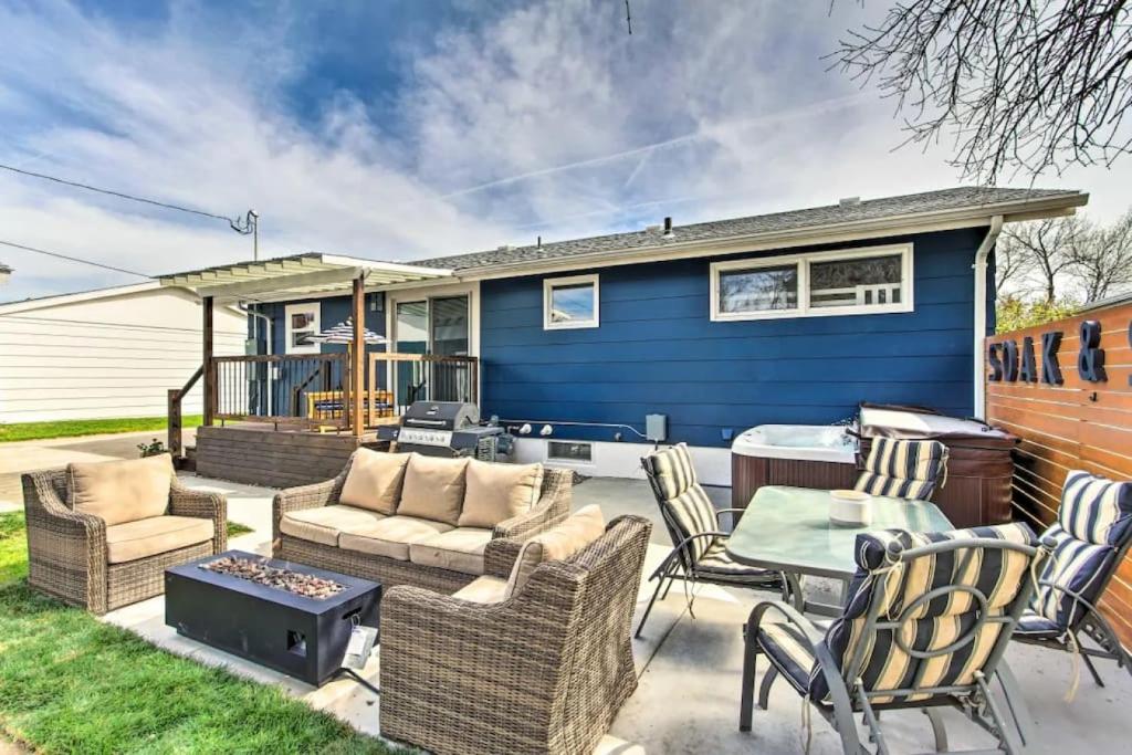 a blue house with a patio with chairs and a table at Sleek Great Falls Retreat in Great Falls