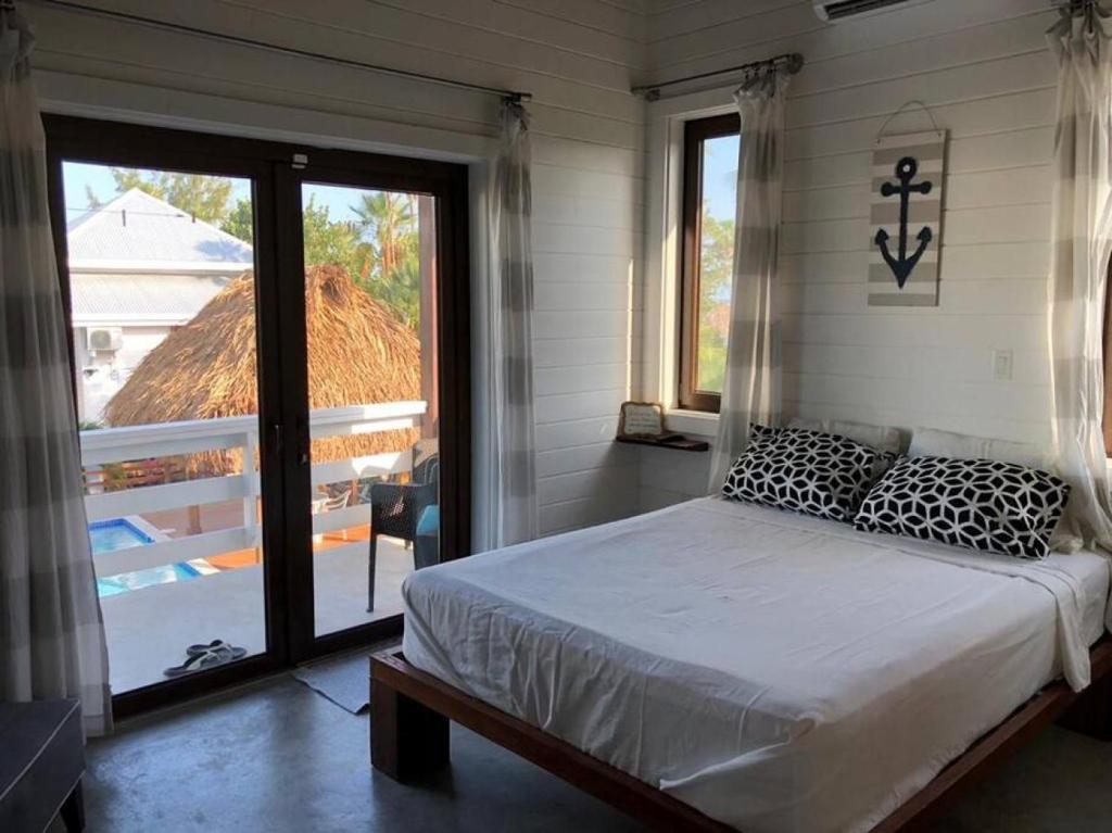 a bedroom with a bed and a large window at La Vida Belize - Casa in Riversdale
