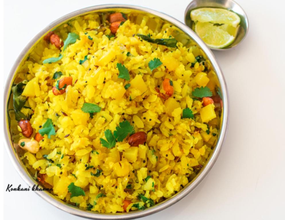 a bowl of yellow rice on a table with a spoon at Hotel Powai Residency in Mumbai