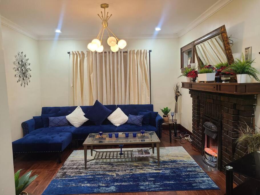 a living room with a blue couch and a fireplace at 3 BR House in Toronto Downtown in Toronto