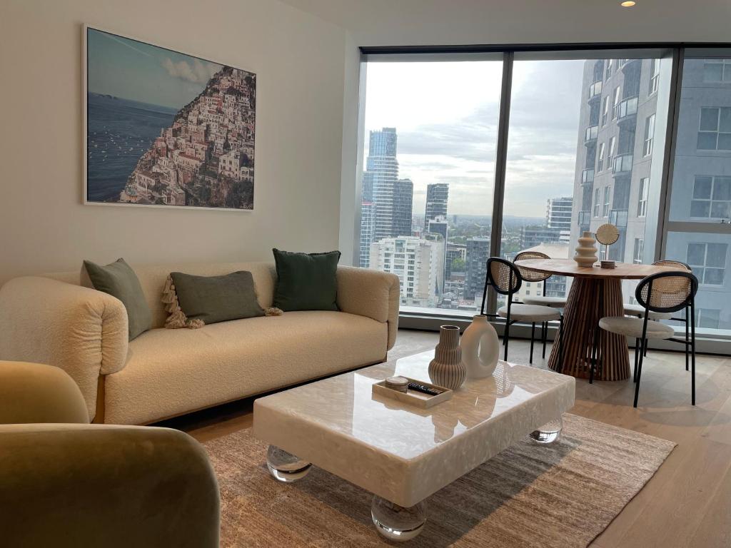 a living room with a couch and a table at Serenity Stayz - 3 Bedroom Apartment in Melbourne CBD in Melbourne