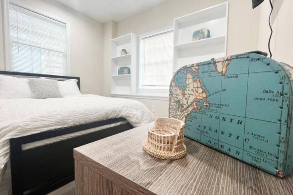 a bedroom with a bed and a table with a map at The Traveler - Your Private Retreat, Inspired by the Spirit of Travel in Manassas Park