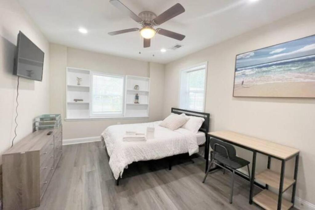 a bedroom with a bed and a table and a ceiling fan at The Beach Pad - Your Private Oasis with a Cool Beachy Vibe in Manassas Park