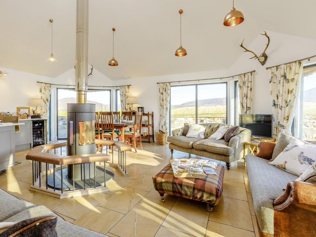 a living room with couches and a table at 4 Bed in The Cairngorms 80298 in Knockandhu