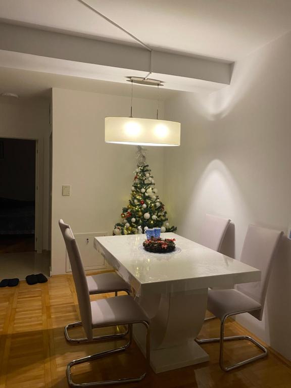 una sala da pranzo con un albero di Natale e un tavolo bianco di CocoLux a Loznica
