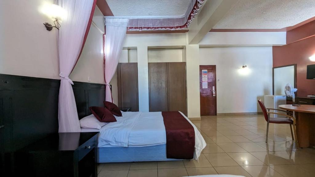 um quarto com uma cama com uma cortina rosa em Jamia Central Hotel em Nairobi