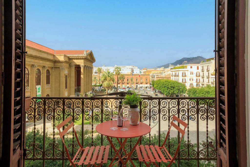 una mesa y sillas en un balcón con vistas en Palermo al Massimo en Palermo