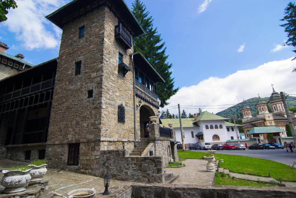 a stone building with a clock tower on a street at Casa Cu Farfurii in Sinaia