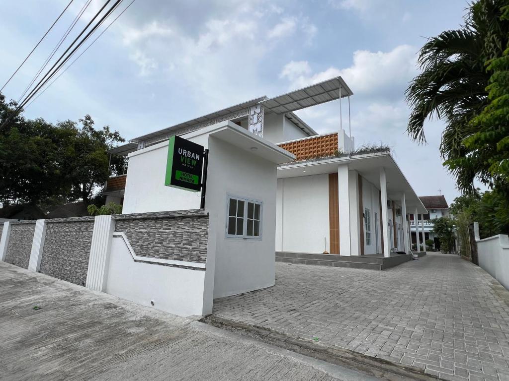 un edificio bianco con un cartello sopra di Urbanview Hotel Nimara Ngawi by RedDoorz a Ngawi