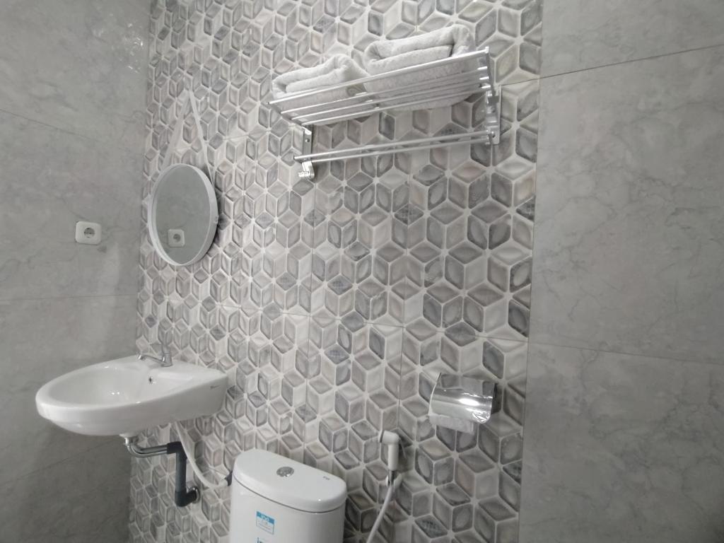 un piccolo bagno con lavandino e specchio di Urbanview Hotel Nimara Ngawi by RedDoorz a Ngawi