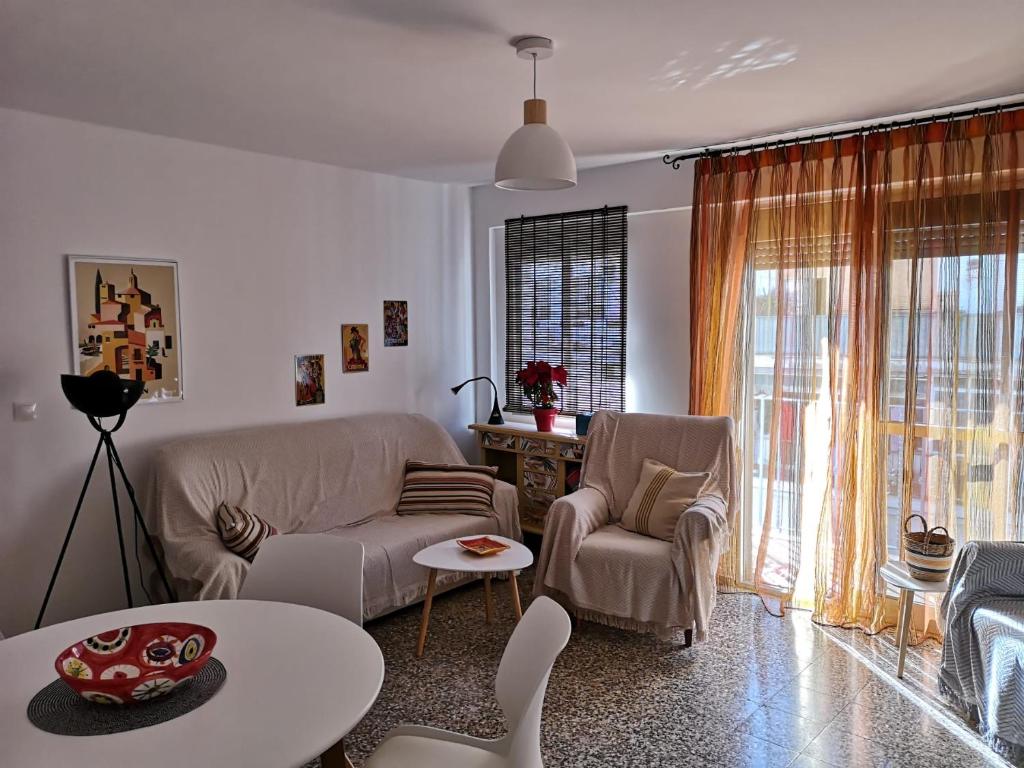 uma sala de estar com um sofá, cadeiras e uma mesa em La Paloma em Córdoba