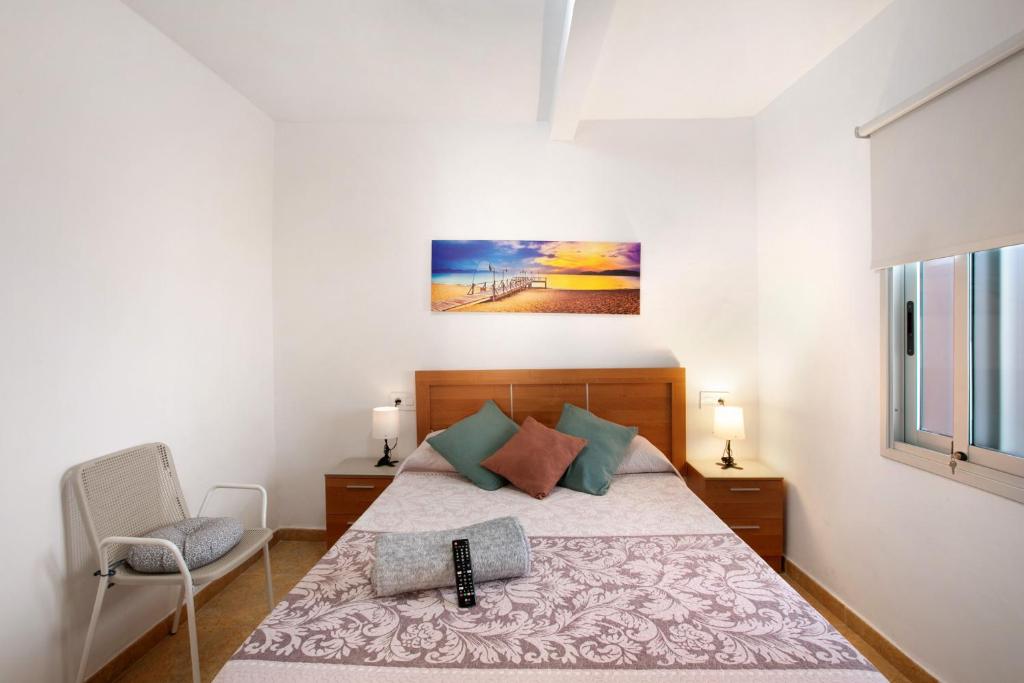 - une chambre avec un lit et une chaise dans l'établissement Apartamento La Morena 3b, à El Pris
