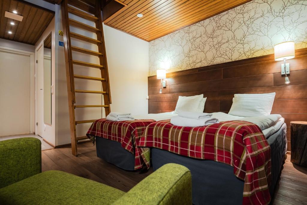 una habitación con una cama y dos sillas y una escalera en Lapland Hotels Sirkantähti, en Levi