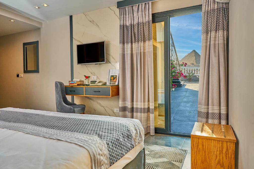 um quarto de hotel com uma cama e uma porta de vidro deslizante em Khan Duidar Inn - Pyramids View Rooftop em Cairo