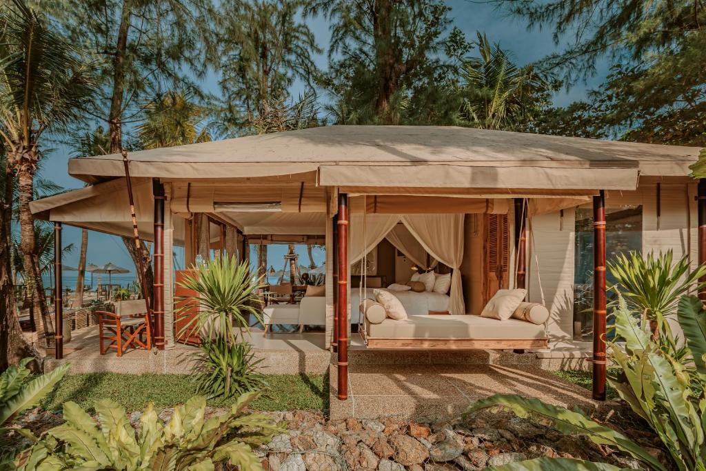 邦濤海灘的住宿－The Lazy Coconut Glamping，一个带床和帐篷的凉亭