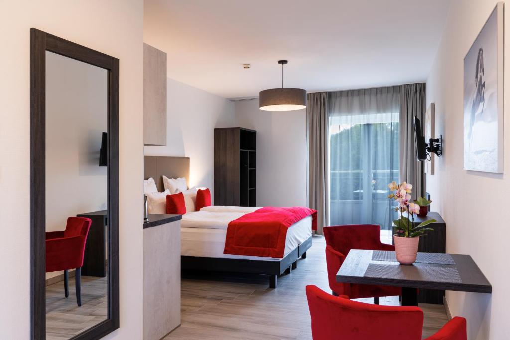 Habitación de hotel con cama, mesa y sillas en Motel-Résidence Ô Pied à Terre, en Montilliez