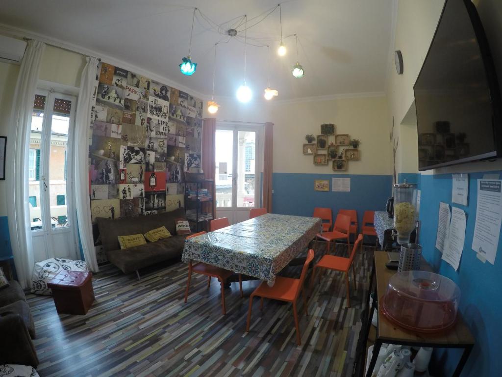 sala de estar con mesa de comedor y sillas en Home Genoa Hostel, en Génova