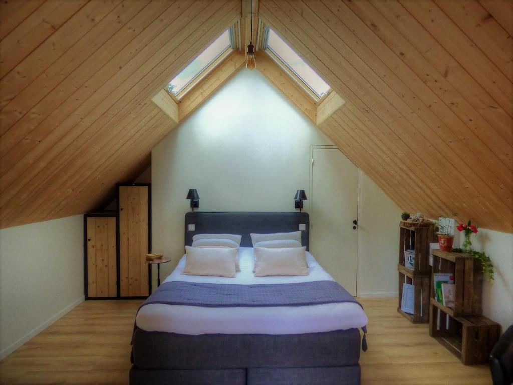 ein Schlafzimmer mit einem großen Bett im Dachgeschoss in der Unterkunft Le Moulin de Follet in Fougeré