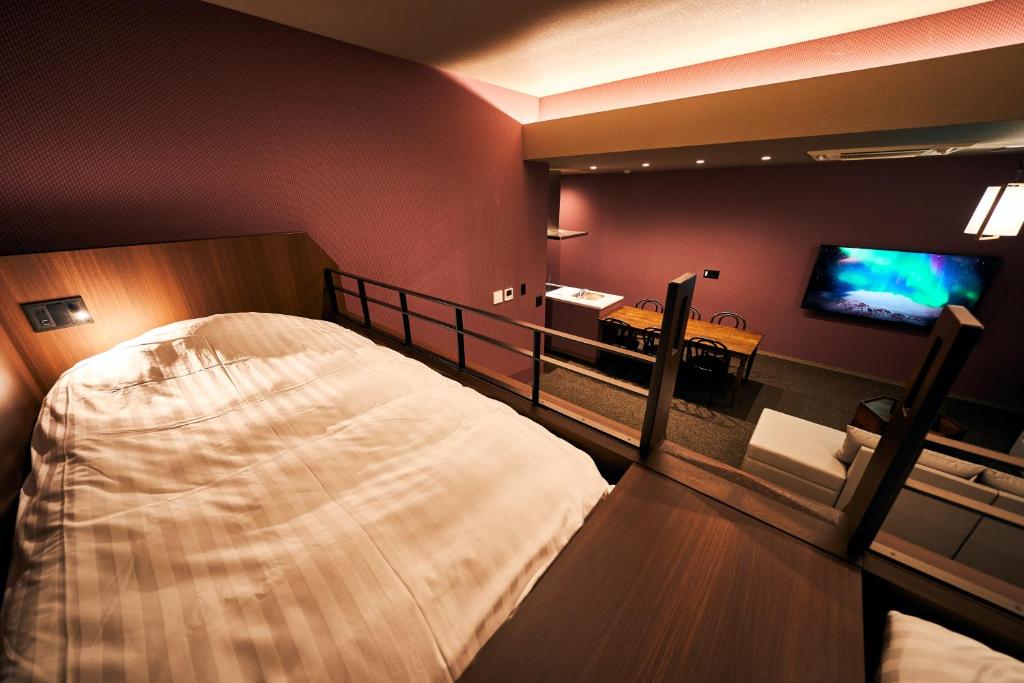 a bedroom with a large bed and a television at Rakuten STAY Kokura Station in Kitakyushu