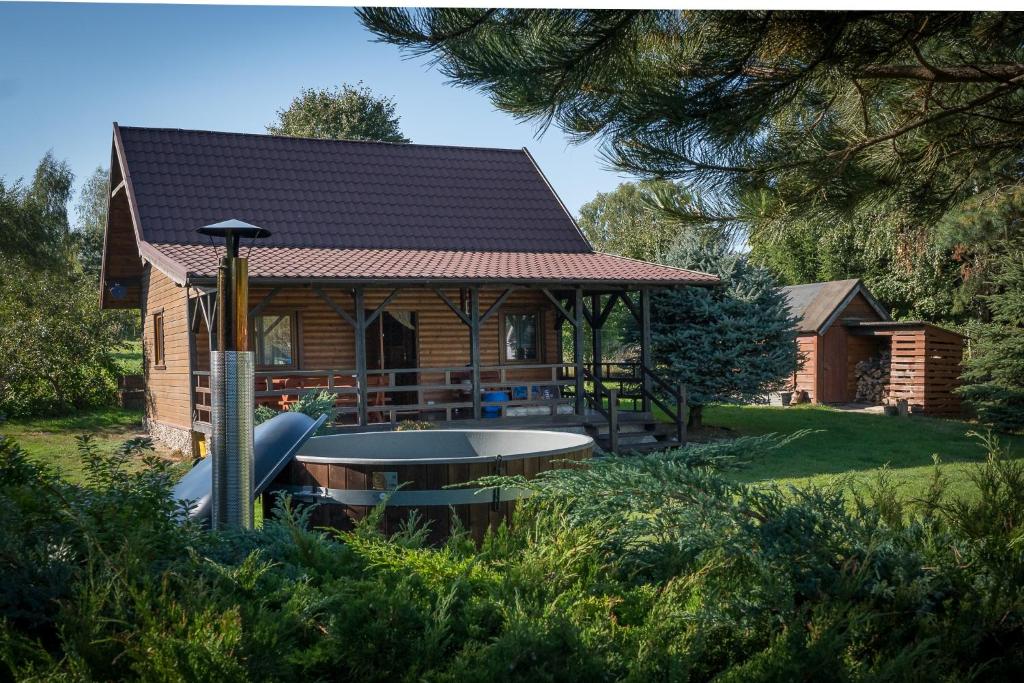 a log cabin with a hot tub in the yard at domek letniskowy in Urowo