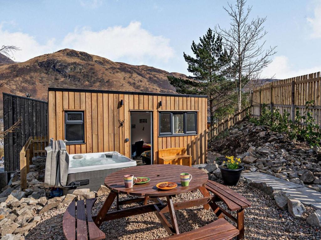 a small wooden cabin with a table and a tub at 1 Bed in Kinlochleven 87131 in Kinlochleven
