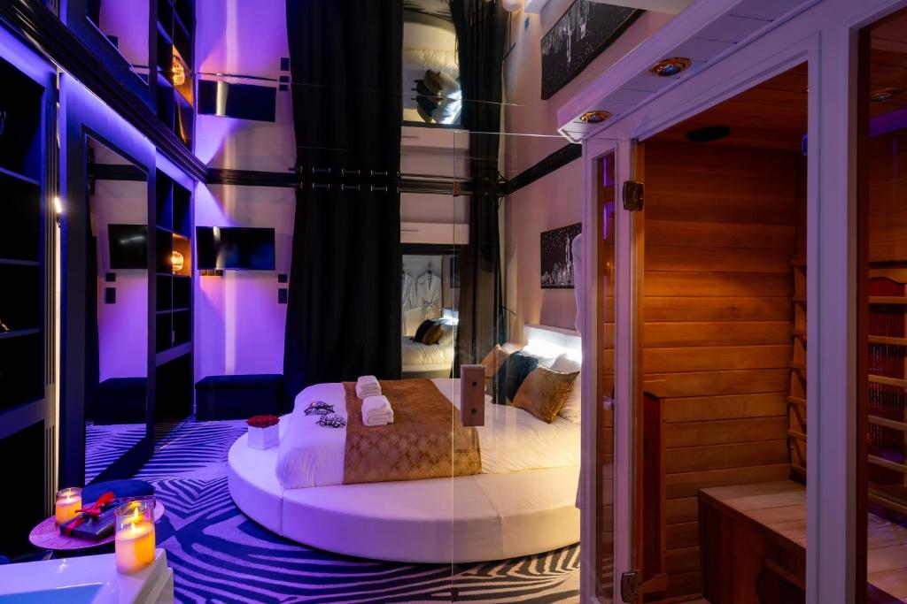 ヴァンヌにあるLe Côté Secretの紫色の照明が備わる部屋のベッド1台分です。