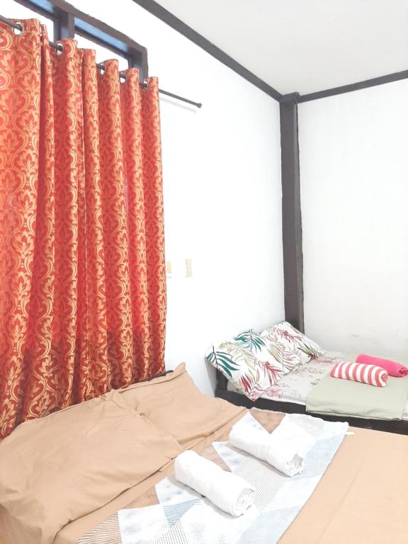 twee bedden in een kamer met oranje gordijnen bij Subangan 2 in Burgos