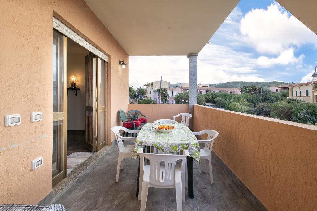a patio with a table and chairs on a balcony at Veranda Vista Mare Isola Rossa in Isola Rossa