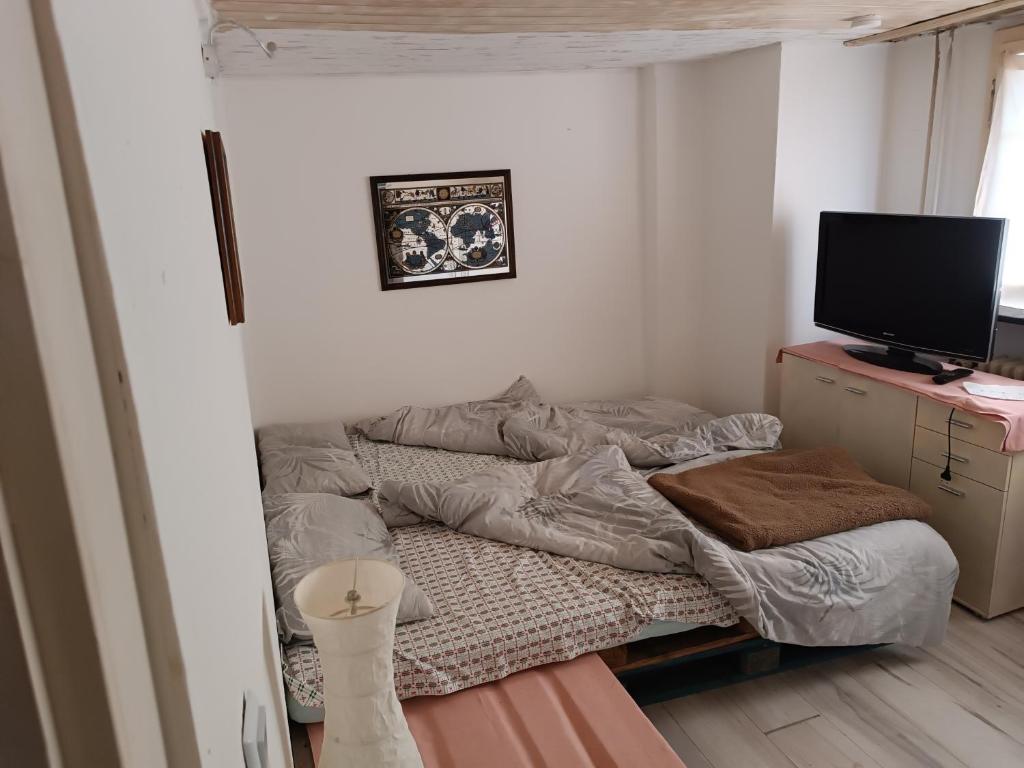 a small bedroom with a bed and a television at Gasthaus Sunnenhof Sonne 