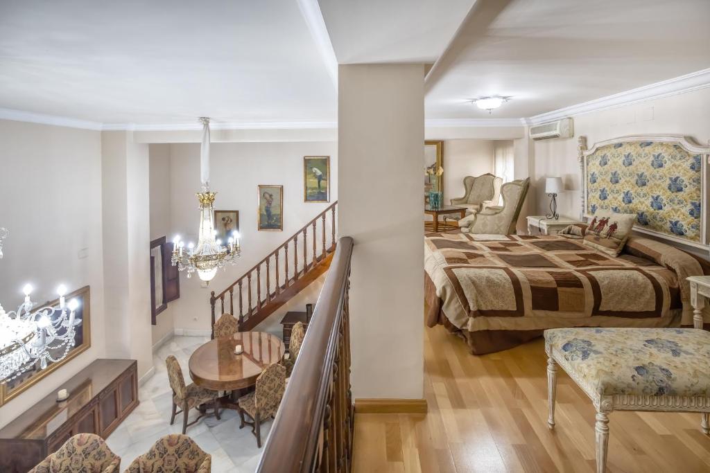 1 dormitorio con 1 cama extragrande y escalera en Palacio Marqués Vega Armijo & Parking incluido, en Córdoba