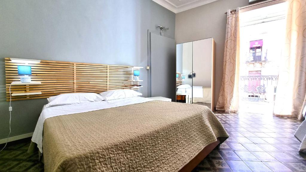Un pat sau paturi într-o cameră la Cortile Stesicoro