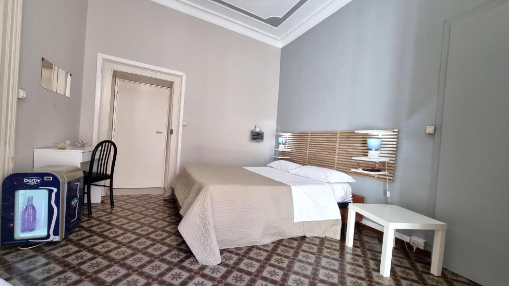 Un pat sau paturi într-o cameră la Cortile Stesicoro