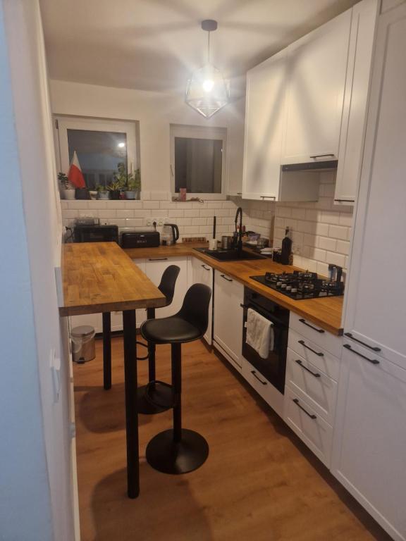 a kitchen with a wooden table and a counter top at Noclegi Budomas Budget Wrocław-Szymanów FreeParking SmartTv in Wrocław