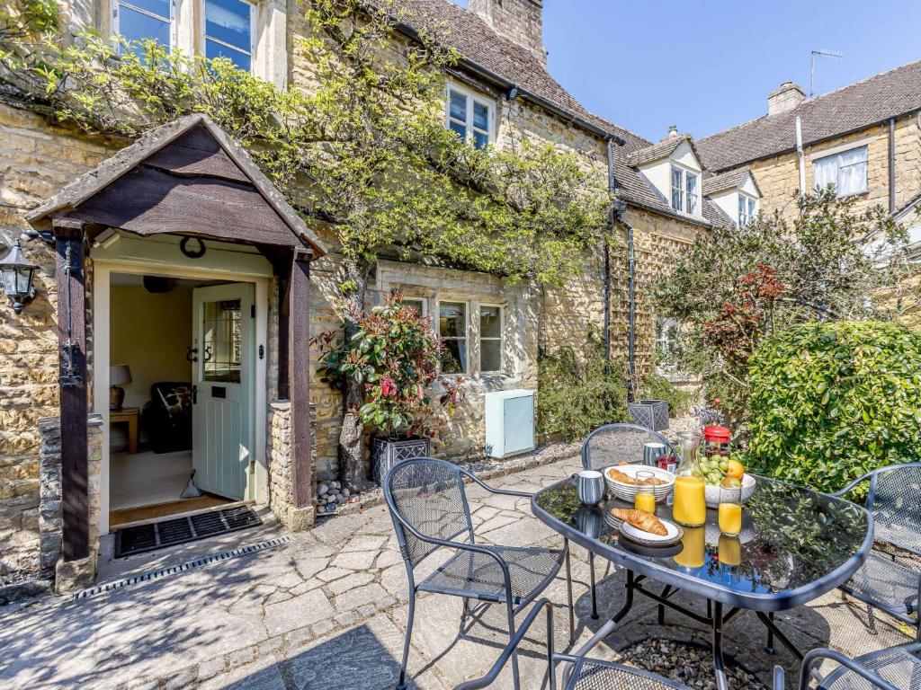 a patio with a table and chairs in front of a building at 3 Bed in Bourton-on-the-Water PTREE in Bourton on the Water