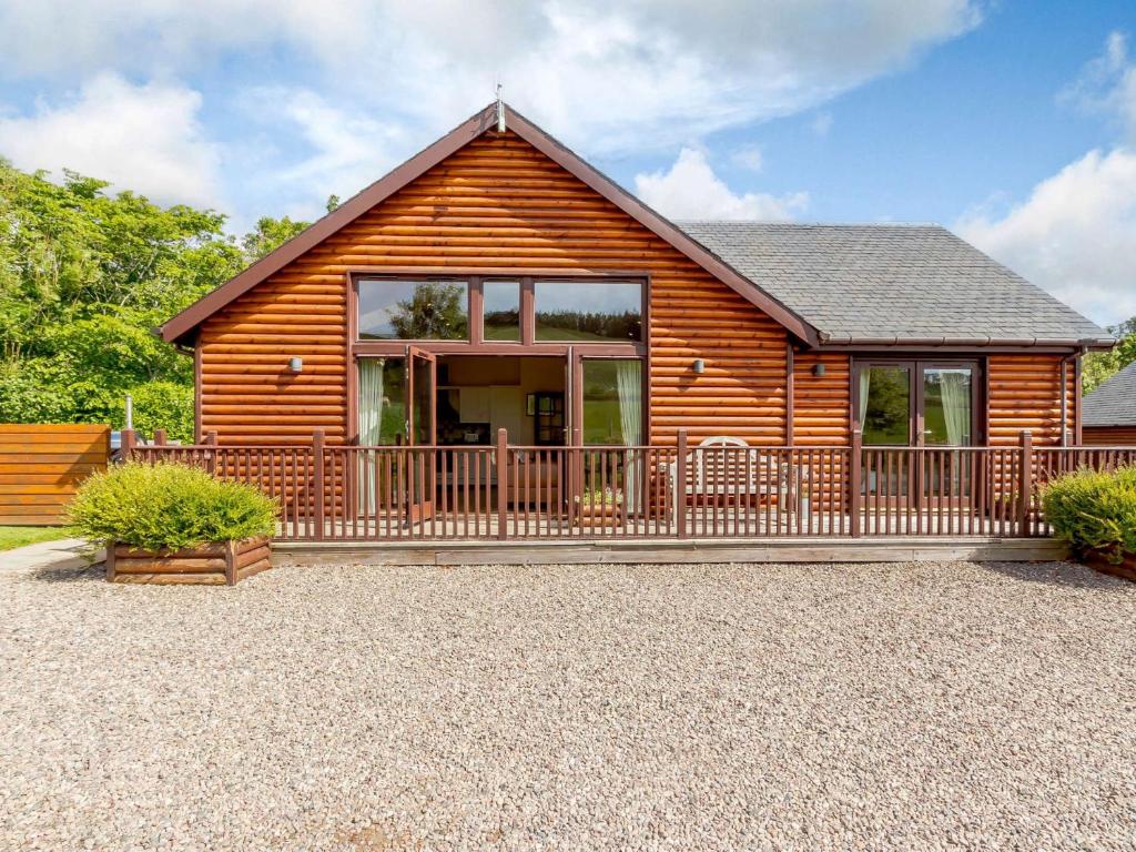 a log cabin with a large balcony in front at 3 Bed in Perth ROWPE in Errol