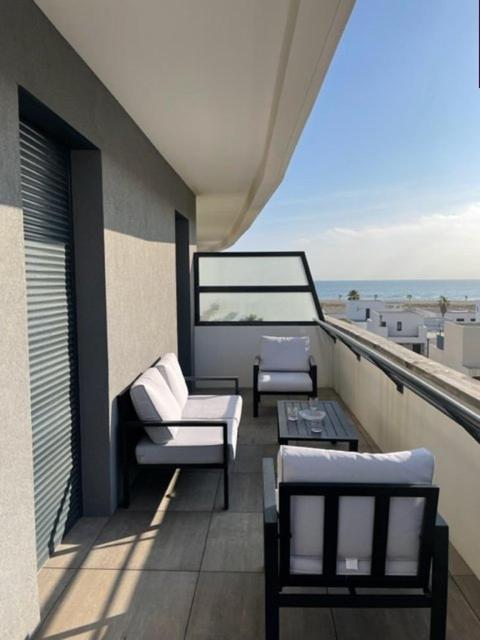 un balcon avec des chaises et une table sur un immeuble dans l'établissement Superbe Appartement T3 - 6 Personnes - 100 m de la plage - Piscine- 6ODYS405D, au Barcarès